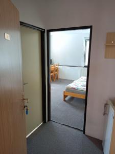 Zimmer mit einer Tür, die zu einem Zimmer mit einem Bett führt in der Unterkunft Penzion Nová Ves in Litovel