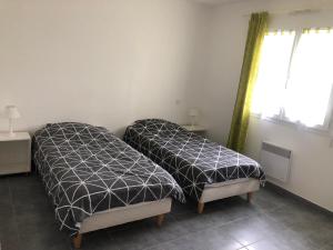 1 dormitorio con 2 camas y ventana en LES IRIS 1 T2 45m2 à 200m des thermes, en Eugénie-les-Bains