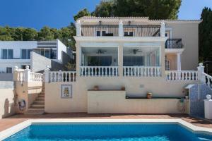 une villa avec une piscine en face d'une maison dans l'établissement VILLA ALTEA HILLS, vue mer, piscine chauffée, WIFI, à Alicante