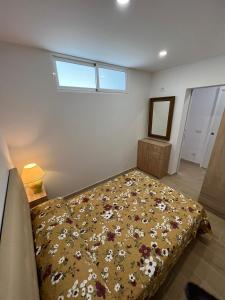 a bedroom with a bed with a bedspread with flowers at Chaparral in Costa Del Silencio