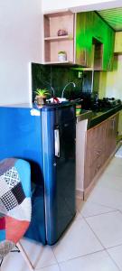 eine Küche mit einem schwarzen Kühlschrank und einer Spüle in der Unterkunft Khalisee Homes Studio Apartment 2 in Voi