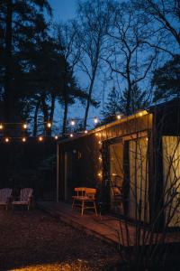 a tiny house with a table and lights on it at Vague Luxurious Tiny House Luxe Wellness, Spa Bad,Beamer, Veluwe in Nunspeet