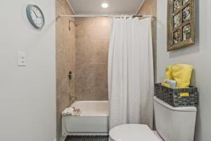 a bathroom with a tub and a toilet and a shower at Urban Chic Apartments Near Center City in Philadelphia