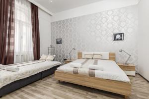 ブダペストにあるReal Apartments Semmelweisのベッドルーム1室(ベッド2台、大きな窓付)