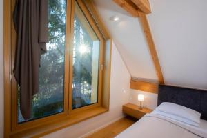een slaapkamer met een bed en een groot raam bij Ambient Resort Bled in Bled