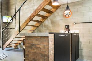 escalera en una habitación con barra y lavabo en Loft com vista para mata!, en Foz do Iguaçu