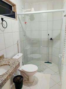 a bathroom with a shower with a toilet and a sink at Amazônia Praia Hotel in Tibau