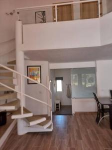 a white staircase in a living room with a table at Mouragolf 3 bedroom townhouse in Vilamoura