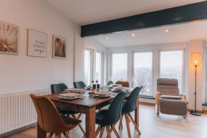 倫山比紹夫斯海姆的住宿－RhönKristall modernes Terrassenhaus mit Weitblick，一间带木桌和椅子的用餐室