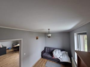 salon z kanapą i pianinem w obiekcie Domki na Kaszubach w mieście Bukowina