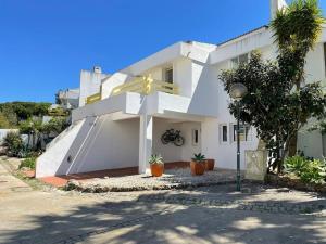 une maison blanche avec une croix sur son côté dans l'établissement Mouragolf 3 bedroom townhouse, à Vilamoura