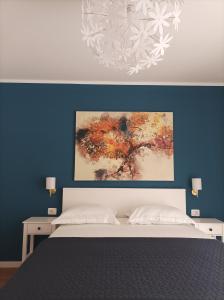 - une chambre avec un lit et une peinture murale dans l'établissement Neda Apartmani, à Mali Lošinj