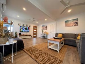 uma sala de estar com um sofá e uma mesa em Sunny Shores House with Private Pool em Lake Illawarra