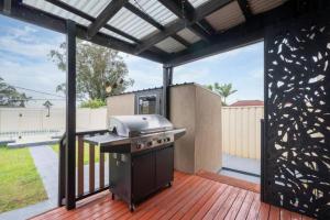 einen Grill auf einer Terrasse in der Unterkunft Sunny Shores House with Private Pool in Lake Illawarra