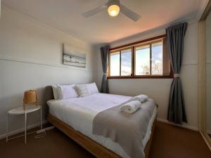 a bedroom with a large bed with a window at Sunny Shores House with Private Pool in Lake Illawarra