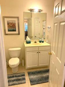 La salle de bains est pourvue de toilettes, d'un lavabo et d'un miroir. dans l'établissement Beach perfect getaway 2 bedroom apartment, à Rehoboth Beach
