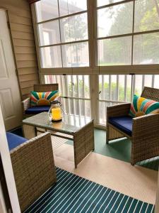 Cette chambre comprend une table, des chaises et des fenêtres. dans l'établissement Beach perfect getaway 2 bedroom apartment, à Rehoboth Beach