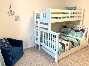 - une chambre avec des lits superposés blancs et une chaise bleue dans l'établissement Beach perfect getaway 2 bedroom apartment, à Rehoboth Beach