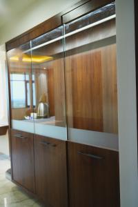 un armario de madera con puertas de cristal en una habitación en Four Petals Executive by LHMS, en Akalkot
