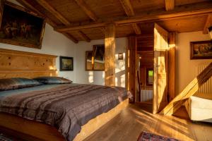 sypialnia z dużym łóżkiem w pokoju z drewnianym sufitem w obiekcie Luxus Chalet Mühlermoos w mieście Ramsau im Zillertal