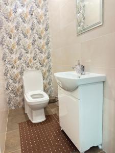 a bathroom with a white toilet and a sink at The Top Hostel in Tashkent