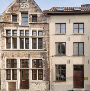 un vecchio edificio in mattoni con porte e finestre marroni di Het Maelslot (Mechelen) a Mechelen