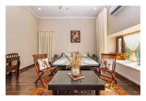 1 dormitorio con 1 cama, mesa y sillas en Tranquility, en Shivpurī