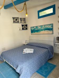 a bedroom with a bed with a blue comforter at Dépendance in San Vito
