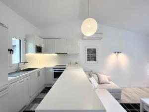 a kitchen with white cabinets and a couch in it at Sani Villa Christy in Sani Beach