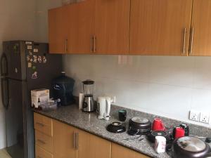eine Küche mit einer Arbeitsplatte und einem Kühlschrank in der Unterkunft JM Apartment in Kigali