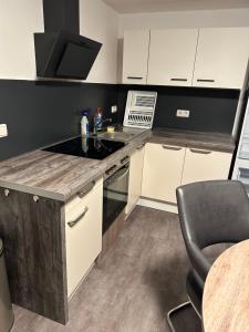 una cocina con estufa horno superior junto a una mesa en Ferienwohnung an der Allee in Memmingen, en Memmingen