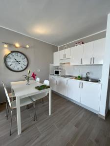 una cucina con tavolo e orologio sul muro di The Colors House, 226 - Private Apartment a Costa Teguise