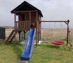 a girl is on a slide in a playground at Domek Letniskowy Kołczewo in Kołczewo