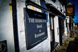 a sign for the rising cross hotel and restaurant on a building at Rising Sun Hotel in Lynmouth