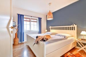 un perro acostado en una cama en un dormitorio en Ferienhaus 1 Fuchsweg en Stralsund