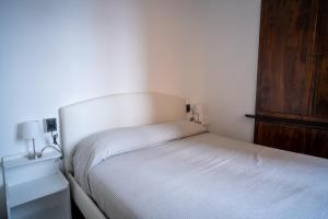 a small bedroom with a bed and a wooden cabinet at Embarcadero with New Powerful WiFi in Camogli