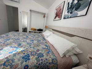 Un dormitorio con una cama con una colcha colorida. en DUPLEX La OLMA en Guadarrama
