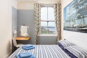 een kleine slaapkamer met een bed en een raam bij Royal Discovery in Whitby