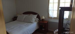 a bedroom with a bed with white sheets and pillows at La maison de Marie in Verteuil-sur-Charente