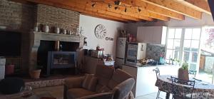 a kitchen and living room with a table and a fireplace at La maison de Marie in Verteuil-sur-Charente