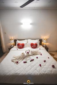a bed with red hearts and flowers on it at Bright Waves Villa in Bentota