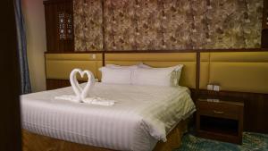dois cisnes brancos sentados em cima de uma cama em فندق جاردن فيو em Tabuk