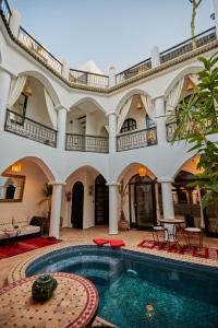 a large house with a swimming pool in a courtyard at Riad Eldar in Marrakesh