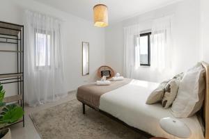 1 dormitorio blanco con 1 cama grande y ventanas en Peniche Coastal Escape, en Peniche