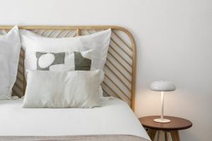 Una cama con una almohada blanca con la palabra ceniza. en Peniche Coastal Escape, en Peniche