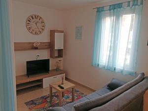 a living room with a couch and a clock on the wall at Apartment Layla - Intermezzo with sea view in center of Rabac in Rabac