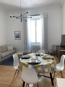 a living room with a table and white chairs at NONSOLOMARE Wifi aria condizionata ascensore in Sanremo