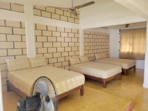um quarto com 2 camas e uma ventoinha em Casa Amarilla em Zihuatanejo