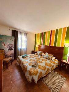 コスタ・テギセにあるThe Colors House, 639 Private Apartmentのカラフルな壁のベッドルーム1室(大型ベッド1台付)