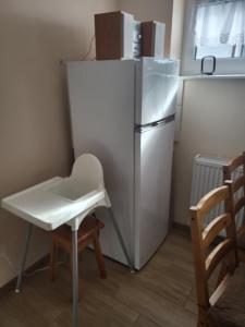 Mörken的住宿－Dom Wiśniowy Zakątek，小厨房配有白色冰箱和椅子